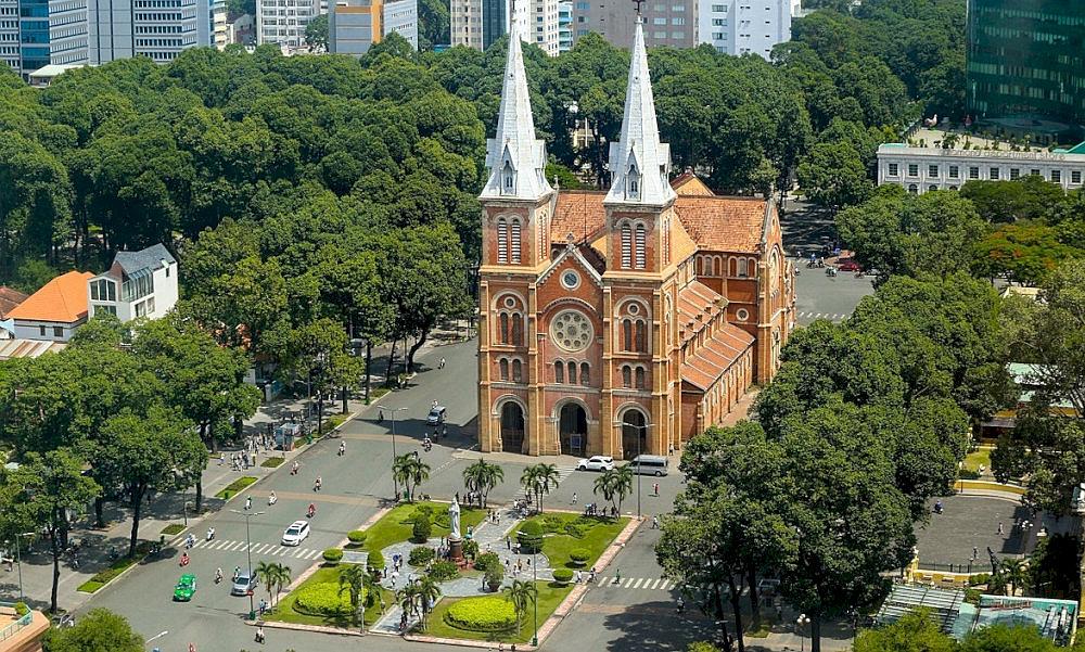 The Notre-Dame Cathedral Basilica of Saigon stands majestically in the square, its twin red-brick bell towers striking against the sky